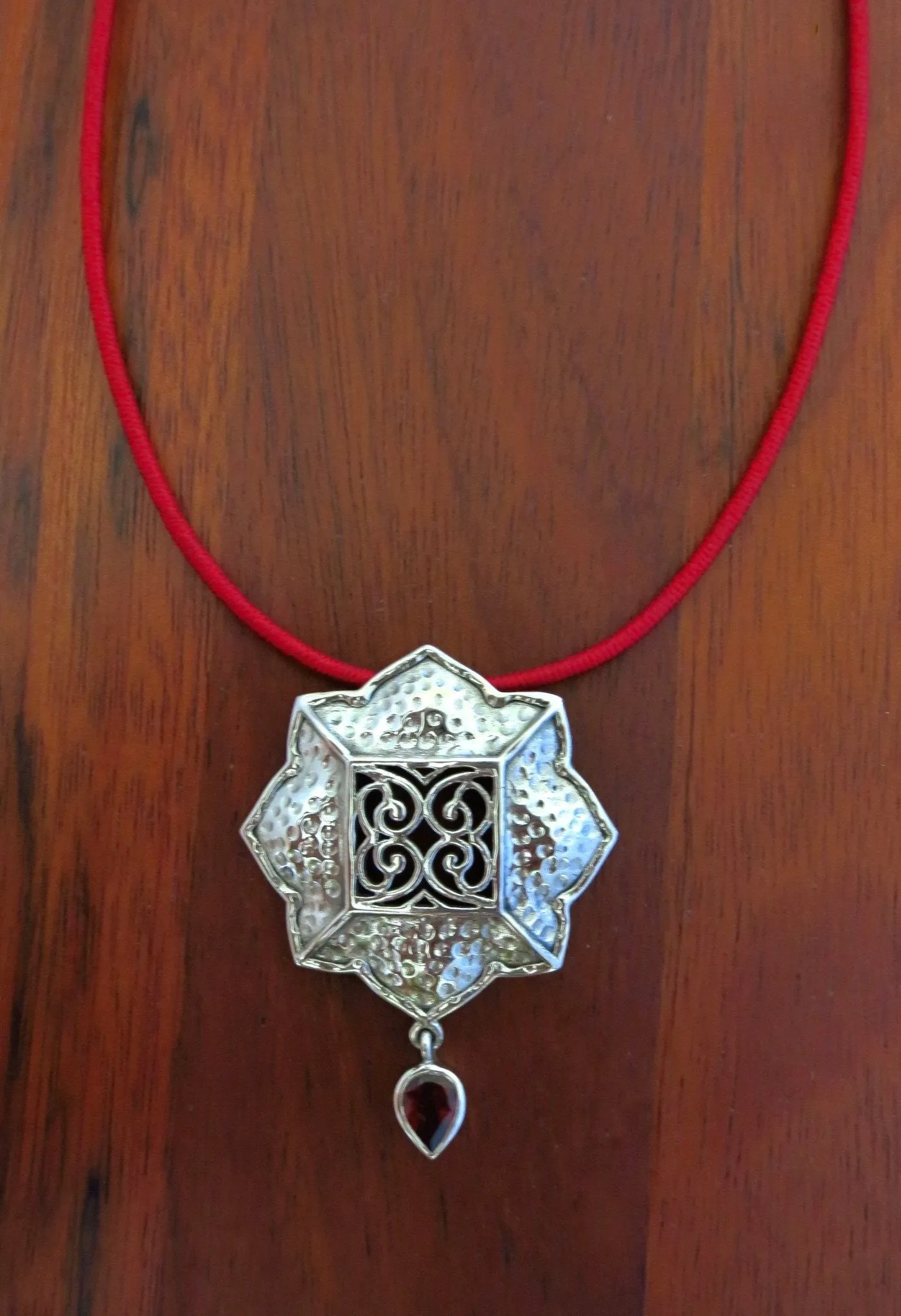 Gorgeous, Kutchi, 8 petal floral hammer finish pendant with jali work & a garnet drop